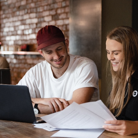 A man and woman sitting next to each other at a computer.