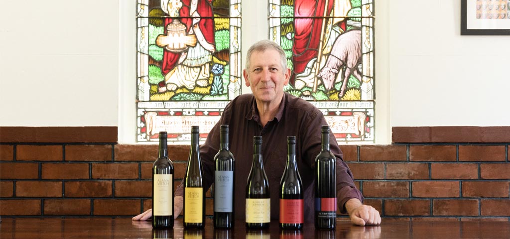 Male standing in front of wine bottles