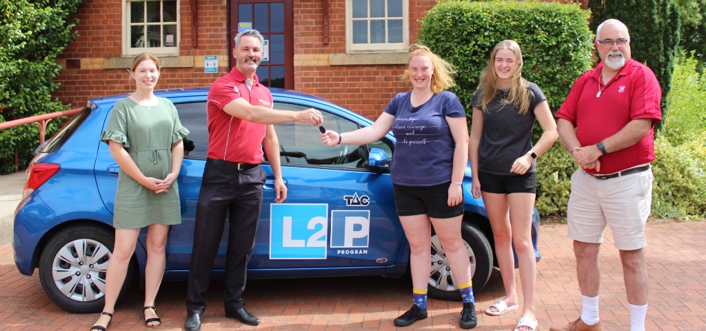 Branch manager handing new car over to L2P program team