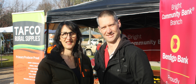Two people at the farmers market, a local event supported by Bright Community Bank Branch.