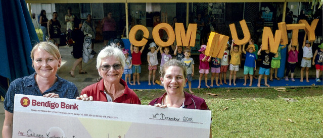 kids holding community letters and people holding a novelty cheque