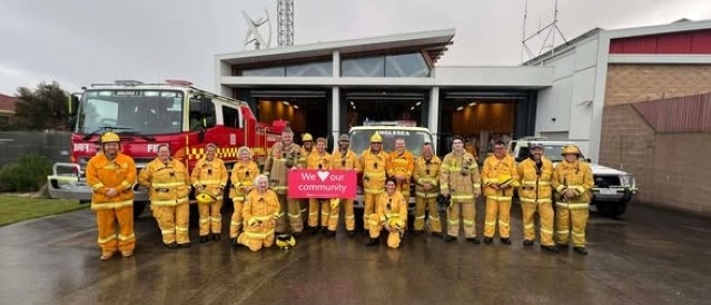 A group of volunteer firefighters standing in front of a fire station