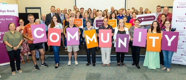 A group of people holding placards that spell 'community'