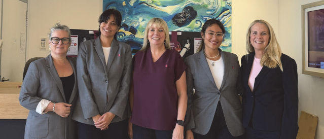 Five female staff members standing at the branch front desk