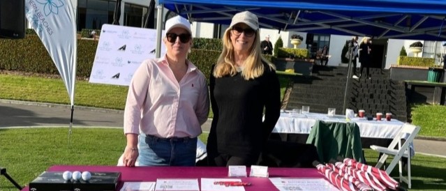 Two females standing at an event stall