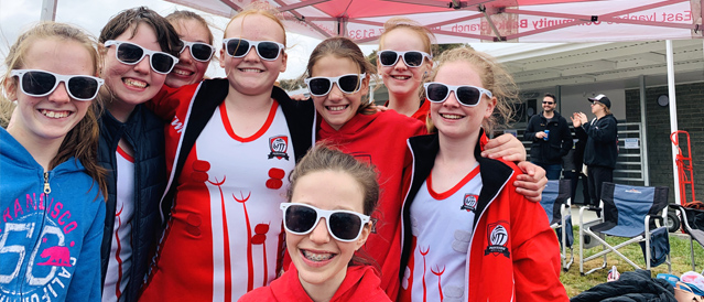 A group of happy young netball players wearing sunglasses