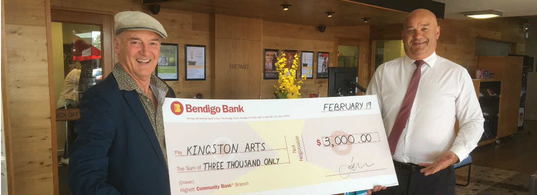 Highett Community Bank Branch staff member and a member of the local arts community holding a novelty cheque representing a grant for the group.