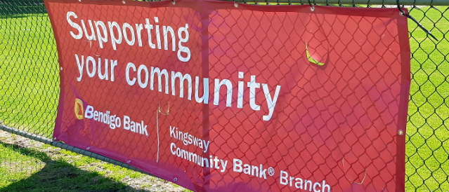 A banner on a fence which states Kingsway Community Bank Branch supports the community.