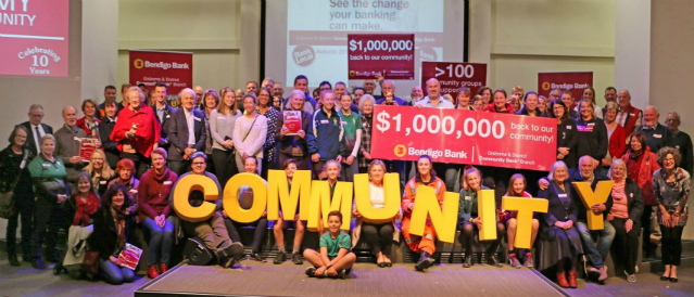 Gisborne Community Bank Branch grant recipients celebrating their grants cheques holding up large yellow letters spelling out the word community.