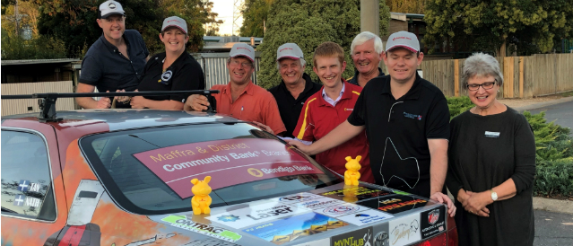 Members of the community and directors and staff of Maffra Community Bank Branch standing behind a rally car sponsored by the local bank branch.
