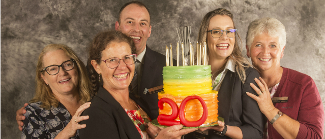 Maldon Community Bank Branch staff and directors holding a cake celebrating the branch's 20 years in business.