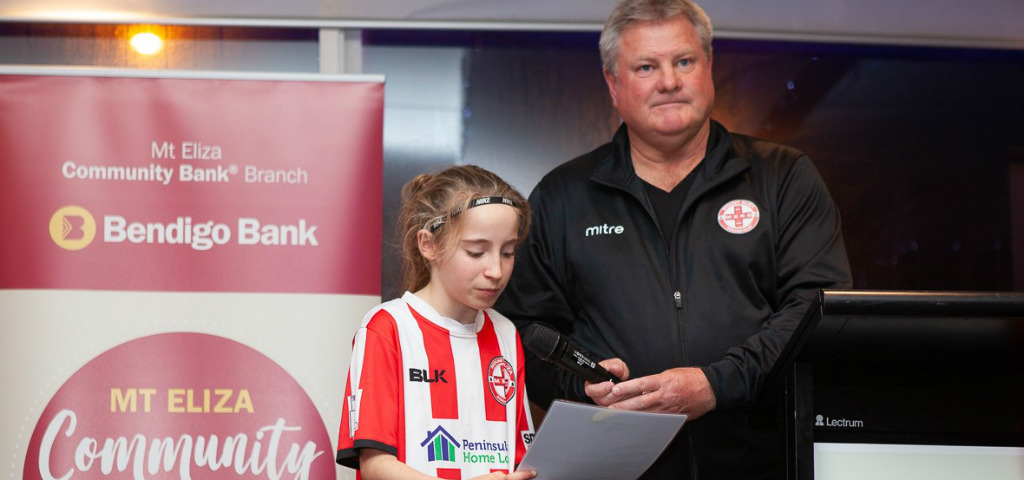 Two local community club members in club uniform presenting for local investment through the Mt Eliza Community Pitch Program.