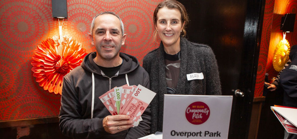 Two local community members holding community pitch dollars showcasing local investment through the Mt Eliza Community Pitch Program.
