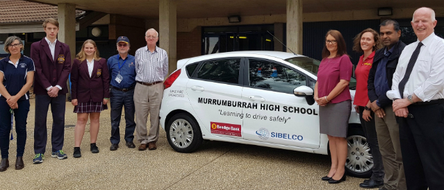 People standing next to a youth driver education car funded by Harden Murrumbeena Community Bank Branch.
