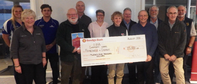 People standing in Paynesville Community Bank Branch holding a novelty cheque which represents a grant to a local group.
