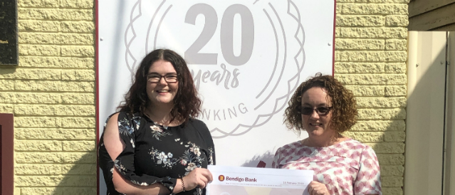 Toora and Foster Community Bank Branch 2019 scholarship recipient with a staff member standing outside the bank branch with a novelty cheque.