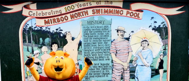 Bendigo Bank Piggy standing in front of the Mirboo North Swimming Pool sign.