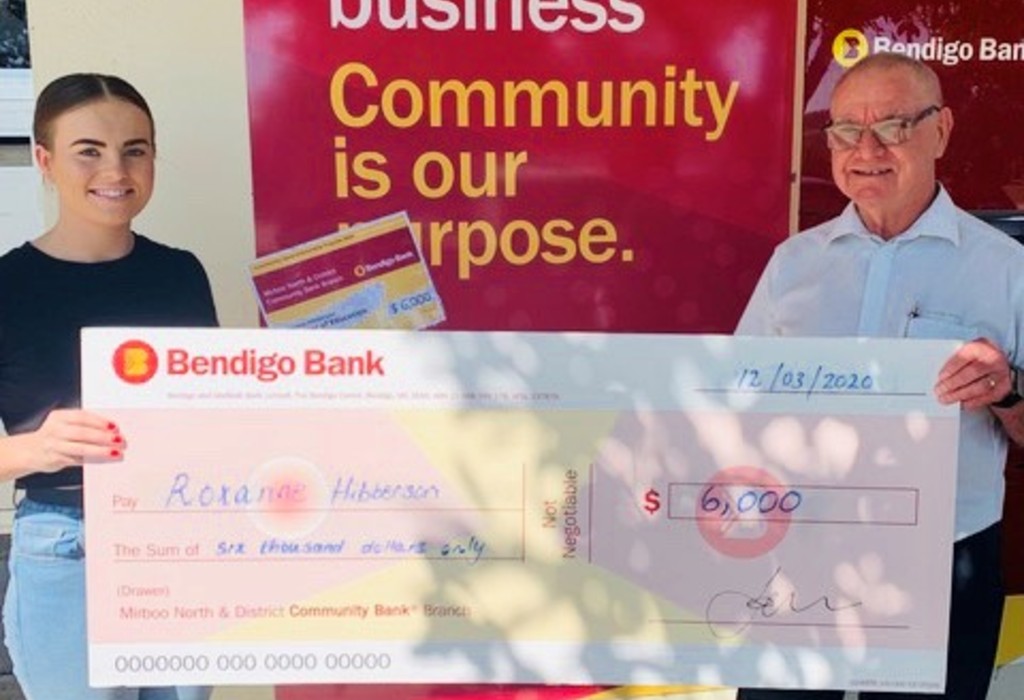 Branch manager handing scholarship recipient cheque.