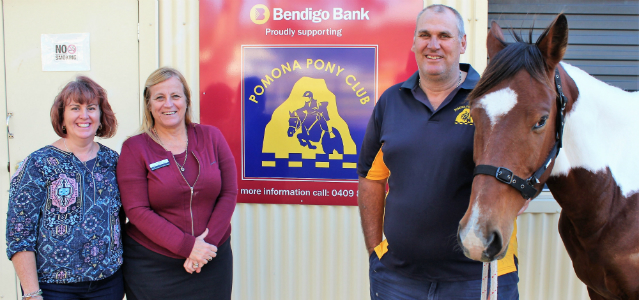 Pomona Pony Club members and Jo from Pomona Bendigo Bank standing in front of pony club sign with a horse.