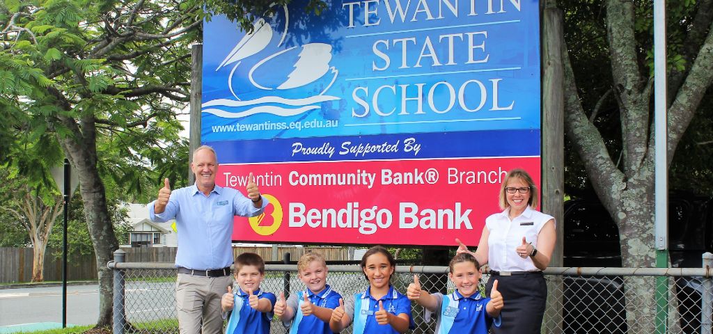 Tewantin State School leaders for 2020 celebrate with principal Rob and Bendigo Bank manager Linda in front of school sign