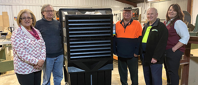 Members of the Kinglake Men's Shed standing with Kinglake branch staff in the shed