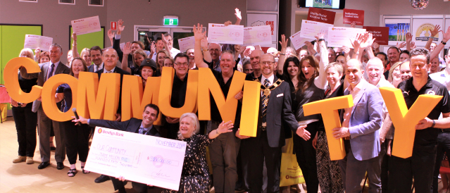 Warrandyte Community Bank Branch representatives holding a novelty cheque during a community event.