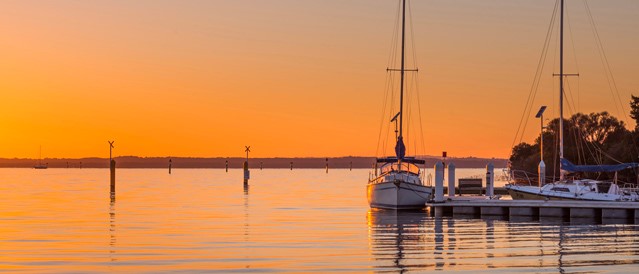 Boats moored on Westernport Bay with sunrise behind