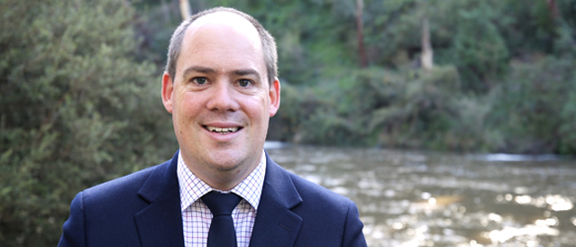 Mobile lender Cameron Mackay standing on the edge of the Yarra River at Warrandyte