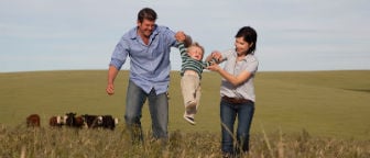 Farming family in a paddock with young son and farm dog.