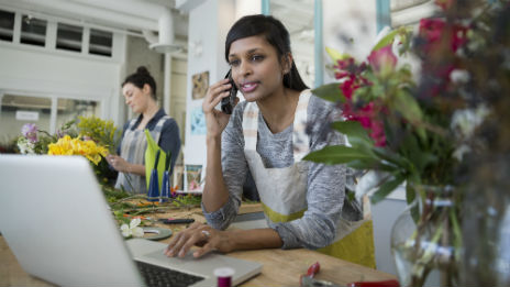Florist shop assistant taking payment in person online