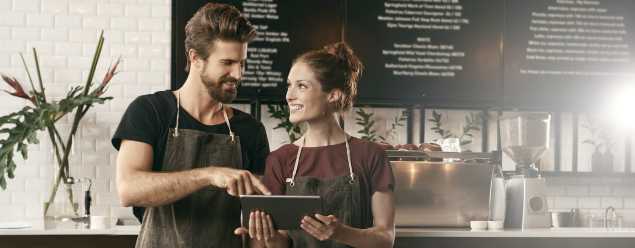 Young man and woman looking at ipad at their business