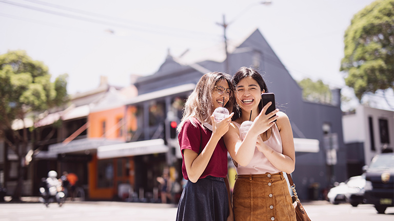 Friends enjoying milkshakes on a sunny day out.